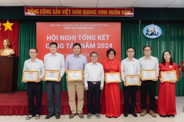 A group of people holding certificatesDescription automatically generated