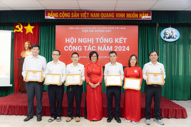 A group of people holding certificatesDescription automatically generated